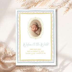 May include: A baby announcement card with a photo of a newborn in a bonnet. The card has a blue and gold floral border and the text "Welcome to the World." The baby's weight is 5.0 kg and length is 49 cm.
