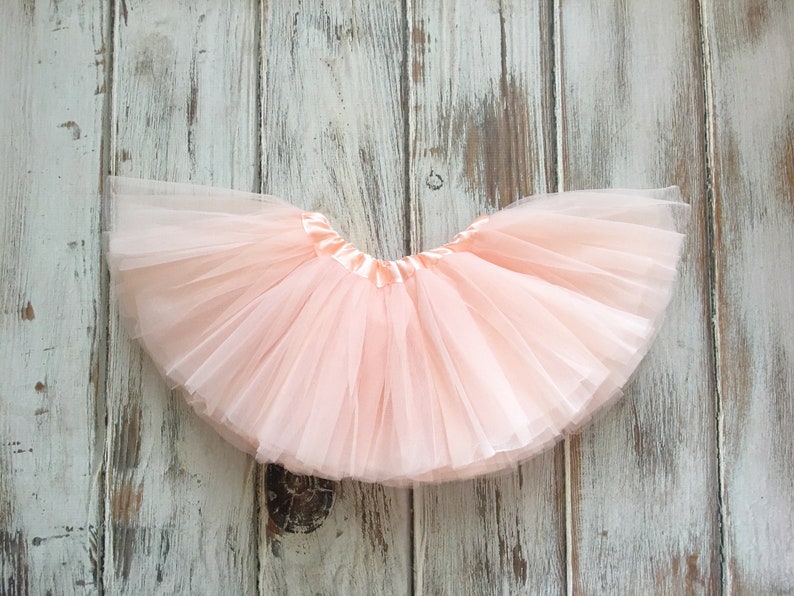 Op de afbeelding: Een lichtroze tule tutu met een satijnen tailleband.