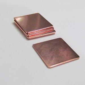 May include: A stack of four square copper heat sinks. The heat sinks are a light copper color and have a smooth, polished surface.