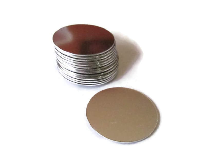 May include: A stack of round, silver metal discs. The discs are smooth and shiny.