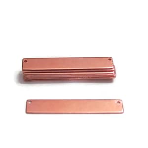 May include: A stack of 10 rose gold metal bar pendants with two holes for attaching jewelry findings. One pendant is shown separately.