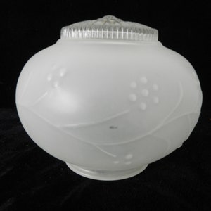 May include: White frosted glass light fixture with a decorative floral design. The fixture has a round shape and a smooth, frosted finish.