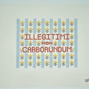 May include: A cross-stitch design on canvas with the phrase "Illegitimi Non Carborundum" in red letters. The background features blue vertical stripes and yellow floral accents. The canvas is off-white.