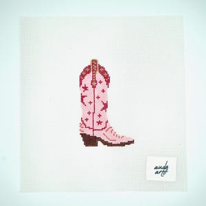 May include: Pink cowboy boot with red and gold stars on a white background. The boot has a brown sole and a gold buckle. The text "andy art" is in the bottom right corner.