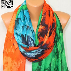 Puede incluir: Una bufanda colorida con un estampado floral en tonos naranja, azul, verde y negro. La bufanda está hecha de una tela ligera y es perfecta para añadir un toque de color a cualquier atuendo.
