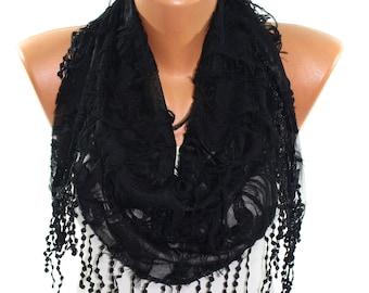 May include: Black lace scarf with beaded fringe. The scarf is draped over a white mannequin bust.