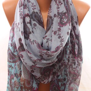 May include: A light blue scarf with a paisley pattern in shades of brown, pink, and teal. The scarf is draped around a mannequin's neck.