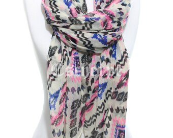 May include: A white scarf with a geometric pattern in black, pink, and blue. The pattern is reminiscent of Native American designs.