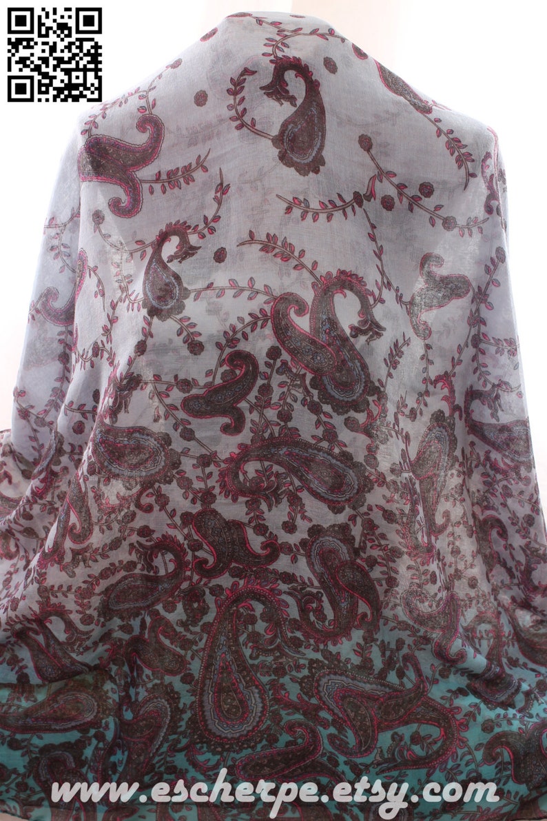 May include: A sheer scarf with a paisley pattern in shades of gray, brown, and pink. The scarf has a gradient effect, fading to a teal color at the bottom. The text "www.escherpe.etsy.com" is printed on the bottom of the scarf.