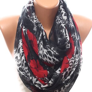 Puede incluir: Una bufanda de estampado de leopardo blanco y negro con detalles florales rojos. La bufanda est&aacute; hecha de una tela ligera y es perfecta para agregar un toque de estilo a cualquier atuendo.