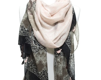 May include: A pink and black patterned scarf with tassels. The scarf is draped over a white mannequin.
