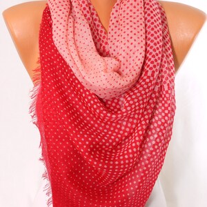 Peut inclure: Une &eacute;charpe &agrave; pois rouge et rose avec une bordure frang&eacute;e. L'&eacute;charpe est faite d'un tissu doux et l&eacute;ger, parfait pour ajouter une touche de couleur &agrave; n'importe quelle tenue.