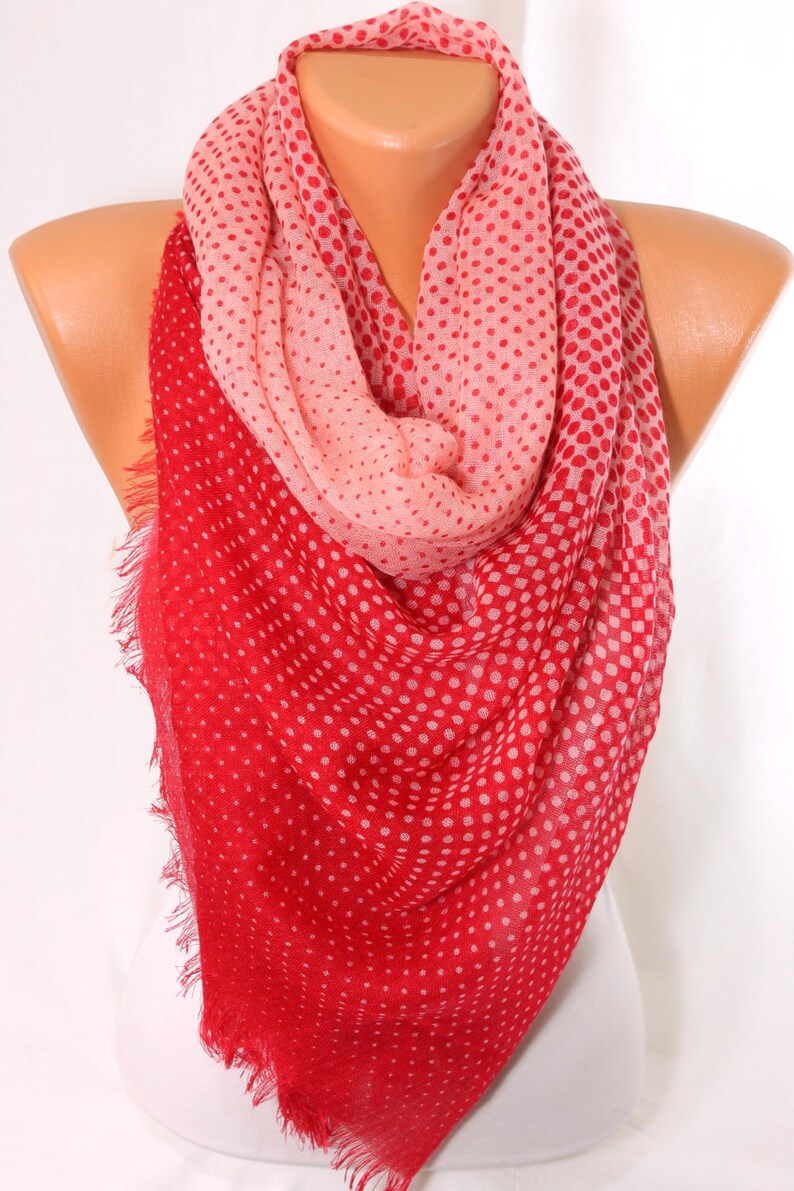 Peut inclure: Une &eacute;charpe &agrave; pois rouge et rose avec une bordure frang&eacute;e. L'&eacute;charpe est faite d'un tissu doux et l&eacute;ger, parfait pour ajouter une touche de couleur &agrave; n'importe quelle tenue.