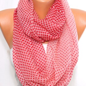 Peut inclure: Une &eacute;charpe infinie rose et rouge &agrave; pois. L'&eacute;charpe est faite d'un tissu doux et l&eacute;ger.