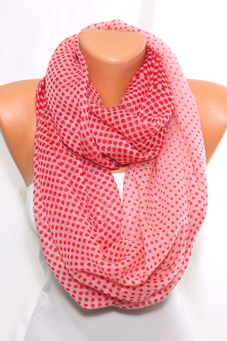 Peut inclure: Une &eacute;charpe infinie rose et rouge &agrave; pois. L'&eacute;charpe est faite d'un tissu doux et l&eacute;ger.