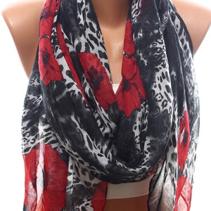 Puede incluir: Una bufanda de estampado de leopardo negro y blanco con detalles florales rojos. La bufanda est&aacute; hecha de una tela ligera y es perfecta para agregar un toque de estilo a cualquier atuendo.