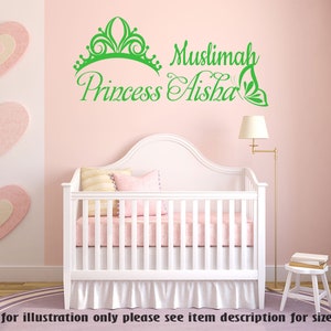 May include: Green vinyl wall decal with a crown, the words "Muslimah Princess Aisha" and a butterfly design. The decal is displayed on a pink wall above a white crib.