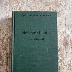 May include: A green hardcover book with the title "Mediaeval Latin" and the author "Harrington" printed on the front cover. The book is part of the "College Latin Series".