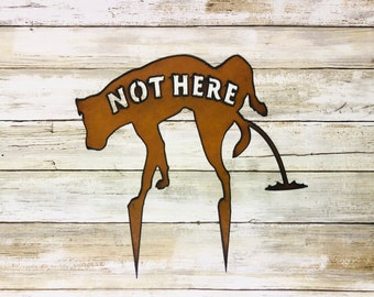 Dog Peeing sign that reads Not Here made out of rusted metal