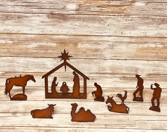May include: Rustic metal nativity scene with a stable, a star, a donkey, a camel, a cow, a rooster, and figures of Mary, Joseph, and baby Jesus.