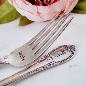May include: A silver fork with the word "bride" engraved on the tines and the date "03.01.20" engraved on the handle.