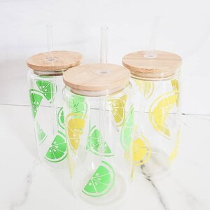 May include: Three glass tumblers with bamboo lids and straws. The tumblers are decorated with a lemon and lime pattern.