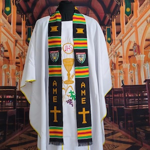 May include: A white cassock with a black and green stole. The stole has the words "AME" and a cross on each side. The stole also has a gold chalice and wheat design in the center.