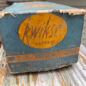 May include: Vintage Kwikset lockset box. The box is teal with an orange oval label that reads "Kwikset Lockset". The box also has the number "300" and the text "Bedroom and Bath".