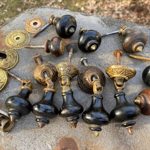 May include: A white ceramic mug with a black handle and the text "But First, Coffee" in a black, handwritten-style font. The mug is on a white surface.