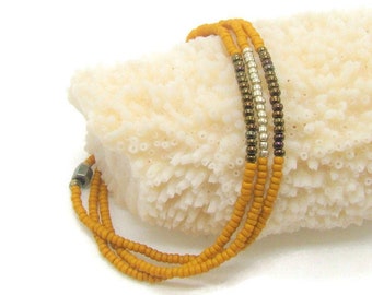 Triple wrap, stretch bracelet with spice yellow, silver, and brown seed beads
