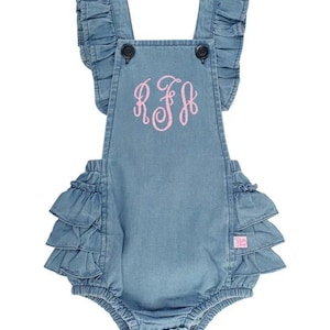 May include: A light blue denim baby romper with ruffled sleeves and a ruffled bottom. The romper has a pink embroidered monogram "R.F.H."