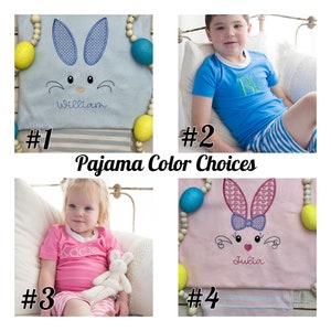 May include: Four images showing different color options for personalized Easter bunny pajamas. The first image shows a light blue pajama top with a blue embroidered bunny face and the name "William". The second image shows a blue pajama top with a white embroidered letter "B". The third image shows a pink pajama top with a white embroidered bunny face and the name "Katie". The fourth image shows a pink pajama top with a pink embroidered bunny face and the name "Julia".