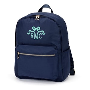 May include: A navy blue backpack with a gold zipper and a light blue embroidered ribbon with the initials "RMC".