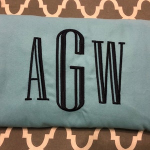 May include: A light blue sweatshirt with the letters "AGW" embroidered in black.