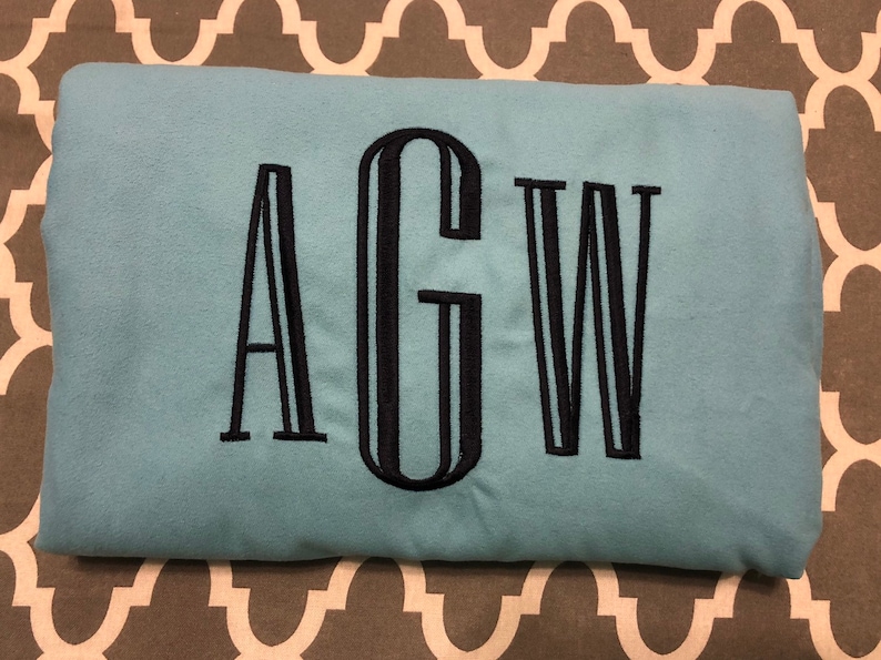 May include: A light blue sweatshirt with the letters "AGW" embroidered in black.
