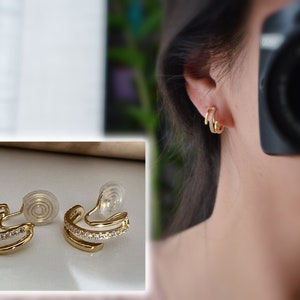 PAINLESS! U-shaped spiral clip-on earrings with triple circles and zirconia rings. Comfortable, delicate ear clips in 18K gold plating.