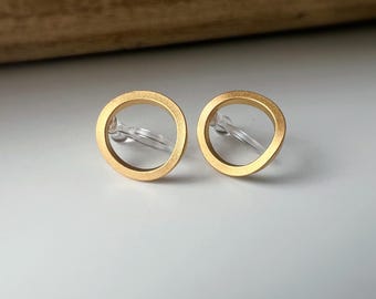 Goudkleurige clipoorbellen in een minimalistisch, opengewerkt cirkeldesign, comfortabel om te dragen, perfect voor een chique touch zonder gaatjes te hoeven prikken.