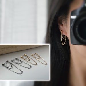 May include: Four pairs of chain earrings with a clear plastic clasp. The earrings are available in gold, silver, and black.