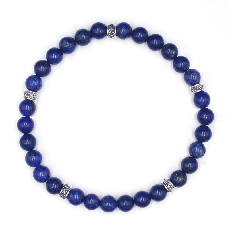 May include: A blue lapis lazuli beaded bracelet with silver accents. The bracelet is made of round beads and has a simple design.