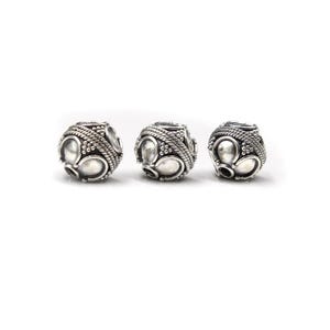 May include: Three silver-colored beads with an intricate design. Each bead features a series of oval and circular shapes, surrounded by a textured, rope-like pattern. The beads are spherical and have a vintage or antique aesthetic.