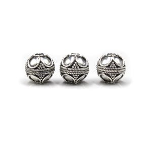 May include: Three silver-colored, round beads with an ornate design. Each bead features a series of curved shapes and a textured band around the center. The beads are displayed against a white background, highlighting their intricate details.
