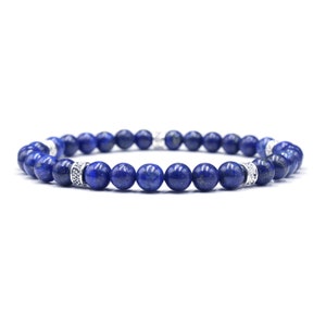 May include: A blue gemstone bracelet with silver accents. The bracelet is made of round beads and has a simple design.