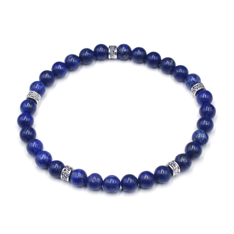 May include: A blue lapis lazuli beaded bracelet with silver accents. The bracelet is made of round beads and has a simple design.