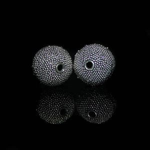 May include: Two silver-colored, spherical beads with a textured surface and a central hole. The beads are displayed against a black background, with their reflections visible below. The beads appear to be made of small, closely packed metallic elements.