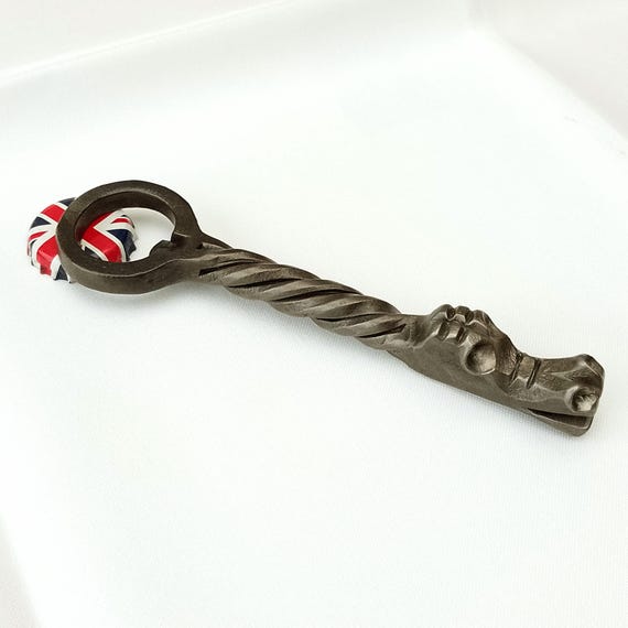 A blacksmith actually hammered a dragon's head onto a functional bottle opener — this is medieval fantasy meets craft beer culture.