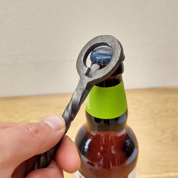 A bottle opener actually hammered into shape by a blacksmith — the kind of functional object that makes you think about the hands and fire that made it.