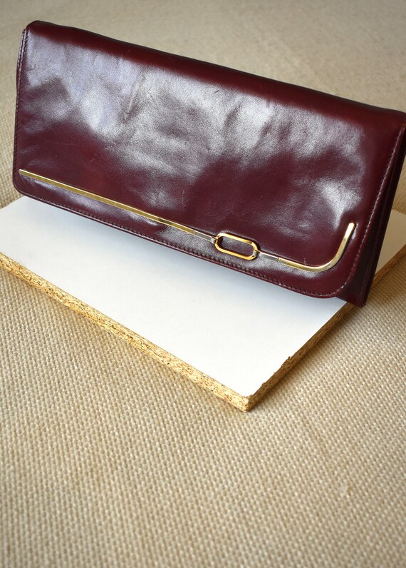burgundy and gold clutch bag
