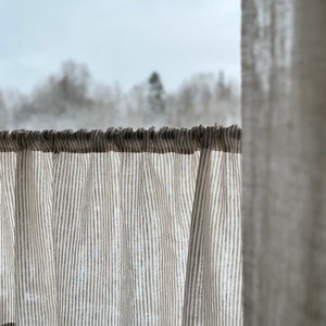 beige narrow stripe cafe style curtain covers lower half of window to give privacy and allow light to enter room