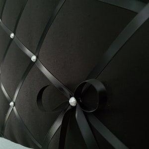 May include: Black fabric bulletin board with a diamond pattern and white pearl accents. The board is decorated with a black satin ribbon tied in a bow.