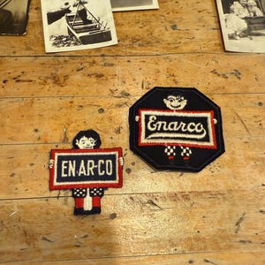 May include: Two vintage Enarco patches with the company name in white lettering. One patch is a figure holding a sign that says "EN-AR-CO". The other patch is a black octagon with the company name in a white rectangle.